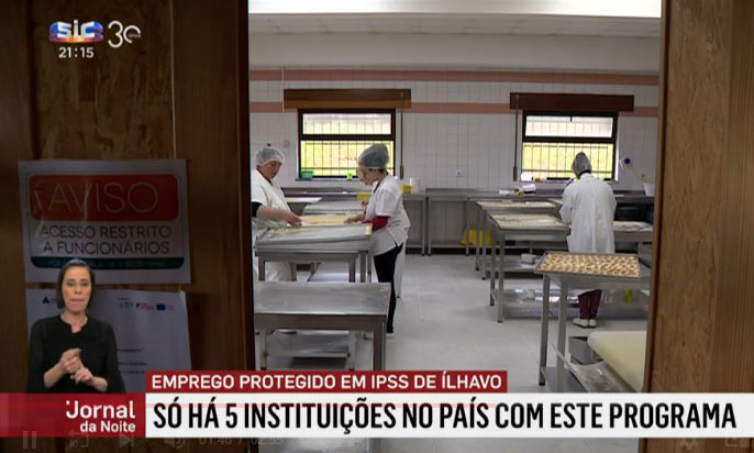 Grupo de pessoas a trabalhar com massa para produzirem biscoitos. Pessoas estas com deficiência.